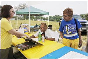 Theresa Moore Isaacs, class of 1970, shows pictures from the Libbey High School yearbook to Hazel Neal Bester, class of 1973, center, and Sara Sydnor, class of 1963.