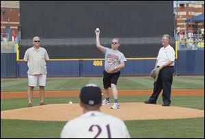 Sylvania police dispatcher Gary Siegel, who is ending his 35-year career, throws out the first pitch. Sylvania Police Chief William Rhodus, left, and Sylvania Mayor Craig Stough watch.