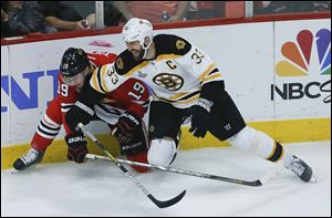 Boston Bruins defenseman Zdeno Chara (33) collides with Chicago Blackhawks center Jonathan Toews (19) in the second period during Game 5 Saturday.