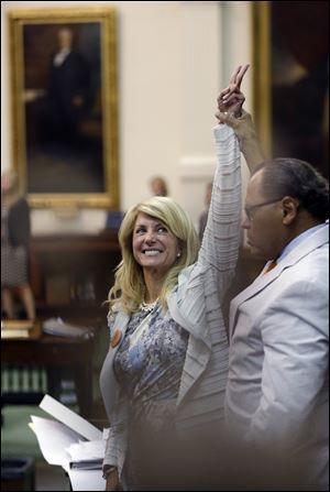 Sen. Wendy Davis, D-Fort Worth, left, who tried to filibuster an abortion bill, reacts as time expires, Wednesday in Austin, Texas. 