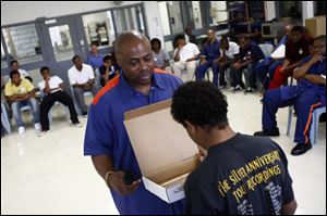 Prisoner Michael 2XTubbs holds a box as a young man looks inside during the Youth Deterrent Program at a Detroit prison. The box, which held only a mirror, 'contains the answers' for the young men to change their ways, Tubbs said. 