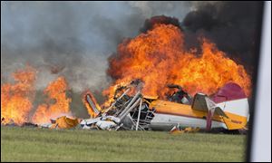 Smoke rises from a stunt plane after it crashed during a wing walker's performance at the Vectren Air Show, June 22, in Dayton, Ohio. The crash killed the pilot and the wing walker instantly, authorities said.