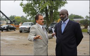 Steve Roumaya, left, a partner in Key Hotel and Property Management of Toledo, speaks with Mayor Mike Bell before a news conference and groundbreaking ceremony.