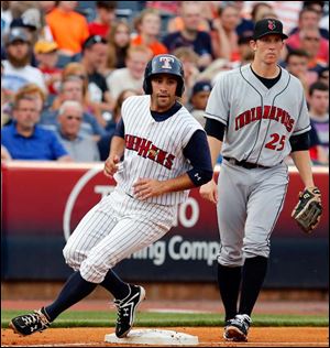 Toledo's Kevin Russo rounds third base as Indianapolis third baseman Jared Goedert looks on in the third inning.