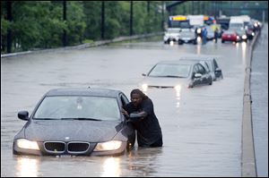 A tow truck driver floats a car out of the Don Valley Parkway.