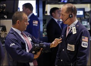 In this Monday, July 8, 2013 photo, traders Joel Lucchese, left, and Michael Urkonis confer on the floor of the New York Stock Exchange. Asian stock markets rebounded and European shares continued a global rally Tuesday July 9, 2013 following positive U.S. economic news as nervousness about an imminent scaling back of the Federal Reserve's monetary stimulus eased. (AP Photo/Richard Drew)