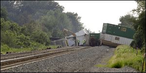 Derailed Norfolk Southern railcars block the east-west mainline in Williams County, near the community of Melbern, Ohio, three miles west of Bryan. 