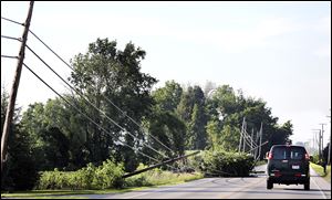 Vehicles avoid downed power lines that litter State Rt. 53 near Tiffin. Hundreds of customers were without electricity throughout the region after the storm. 