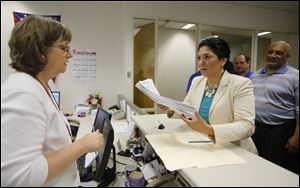 Lucas County Auditor Anita Lopez  hands her petitions to run for mayor of Toledo to Lori Jacek at the Lucas County Board of Elections today inside One Government Center.