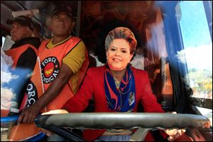 A demonstrator, wearing a mask in the likeness of Brazil's President Dilma Rousseff, sits in the driver's seat of a bus during a protest in front of the Planalto presidential palace in Brasilia, Brazil, today.