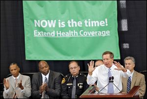 Ohio Governor John Kasich explains to a crowd in the Ohio Statehouse atrium why he believes the legislature should extend health coverage through Medicaid.