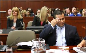 George Zimmerman wipes his face today after arriving in the courtroom during his trial at the Seminole County Criminal Justice Center.