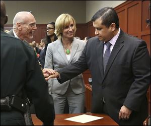 George Zimmerman, right, is congratulated by his defense team after being found not guilty of second-degree murder in the fatal shooting of 17-year-old Martin in Sanford, Fla.