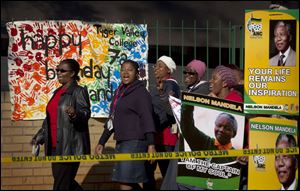 Arriving well-wishers sing as they pass a banner left by schoolchildren wishing Nelson Mandela a happy birthday, outside the Mediclinic Heart Hospital where former South African President Nelson Mandela is being treated in Pretoria, South Africa.