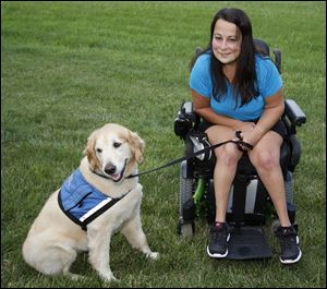 Arrica Okenka with her service dog Ingrid at her home Saturday, in Toledo. Someone tried to steal her dog on a Tarta Bus.