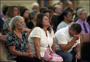 The grandmother, left, mother, and father of Aurora movie theater shooting victim Micayla Medek mourn during a memorial mass held for families and supporters of those killed, at St. Michael the Archangel Catholic Church, in Aurora, Colo.