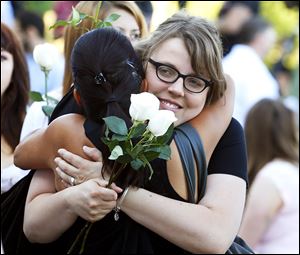 Jasmine Christman, left, is comforted by her mother Yulanda Vega Jordan, center, and father Jack Jordan today during a memorial service in Aurora, Colo.