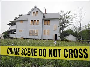 Crime scene tape surrounds the boarded up home of Michael Madison in East Cleveland. Madison has been charged in the deaths of three women whose bodies were found within 250 feet of his home.