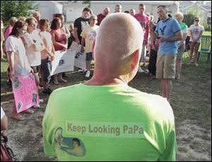 Richard Schiewe, grandfather of Elaina Steinfurth, listens to the Rev. Steve Salyers during a vigil for Elaina Steinfurth, who has been missing since June.