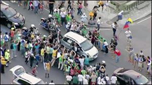 In this image from video, a crowd mobs the silver Fiat carrying Pope Francis through Rio de Janeiro on Monday, July 22, 2013. Ecstatic believers forced the closed Fiat to stop several times as they swarmed around during the drive from the airport to an official opening ceremony in the center of the city.