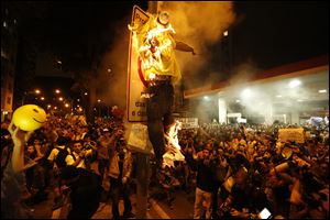 Protesters burn a puppet that symbolizes Rio de Janeiro State Governor Sergio Cabral during a demonstration near Guanabara Palace in Rio de Janeiro, Brazil, Monday. Police and anti-government protesters clashed outside the palace hosting Pope Francis welcoming ceremony. About an hour after the pope concluded his short speech, police began cracking down on the protests, firing rubber bullets in an effort to disperse the crowd. 