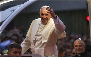 In this photo released by Prefeitura do Rio, Pope Francis waves to people from his popemobile in Rio de Janeiro, Monday, July 22, 2013. Pope Francis returned to his home continent for the first time as pontiff, embarking on a seven-day visit meant to fan the fervor of the faithful around the globe.