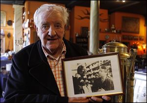 Eduan Naude, poses with photos of celebrities, including former president Nelson Mandela, front left, with co-owner and partner, Brian Shalkoff, in the Gramadoelas restaurant.