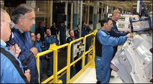 Chrysler Group LLC Chairman and CEO Sergio Marchionne, left, watches a demonstration in the paint shop at Chrysler Group’s Toledo Assembly Complex on Thursday. This was his first visit since 2011, when he announced a $500 million investment in the plant to make the new Cherokee.