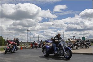 Mike Nagy of Perrysburg, right, rides out with other bikers at the beginning of the 10th Anniversary Porky's Memorial Ride at Signature Harley Davidson in Perrysburg. About 90 people on 60 bikes rode the 57.2 miles together Sunday to honor Porky Myers, who died in 2003.