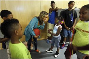 Teacher Kayla Lindsey of Washington, D.C., holding the ball, answers a question from Heaven Mixon, 7, right, of Toledo at  Ebenezer Missionary Baptist Church. The JLJ program helps students academically and with reaching their potential.