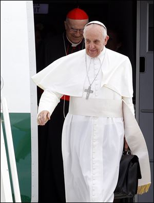 Pope Francis, holding his bag and followed by Vatican secretary of State Cardinal Tarcisio Bertone, disembarks from the plane after landing from Rio de Janeiro, Brazil, at Ciampino's military airport, on the outskirts of Rome, today. The pontiff returned after a week in Brazil. 