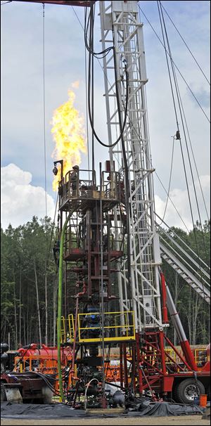 A plume of gas burns as work progresses at an Encana Corp. tracking site in  Michigan.