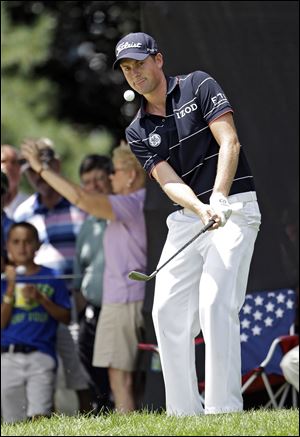 Webb Simpson chips to the ninth green during the first round of the Bridgestone Invitational golf tournament Thursday at Firestone Country Club in Akron.