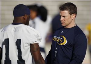 Jason Candle, passing game coordinator, speaks with a Rockets player at a 2012 practice.