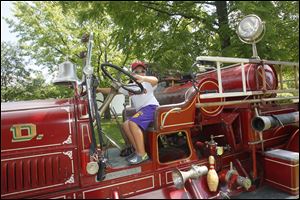 Brock Heard, 5, of Maumee rings the bell on the city’s 1928 Ahrens Fox rotary gear pump fire truck.   The city of Maumee kicked off its anniversary celebration Sunday at the Wolcott House. 