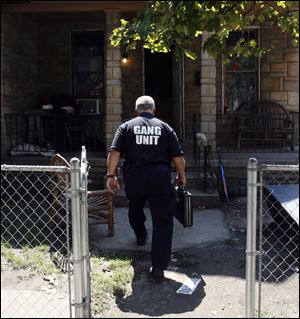 Doug Allen of the Toledo Police gang unit enters a home.