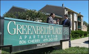 Jack Ford, left, talks with Joe McNamara, city council member and mayoral candidate, in front of the troubled Greenbelt Place Apartments on Wednesday.