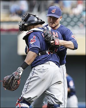 Joe Smith, right, and Carlos Santana celebrate the Indians' 12-inning win against the Twins.