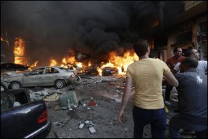 Lebanese citizens gather at the site of a car bomb explosion in southern Beirut, Lebanon today.