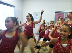 Katelyn Petrie, 9, dances at the Perrysburg Academy for Performing Arts with Maiya Combest, 7,  right. The group of 20 is heading to Cedar Point to take a class and perform.