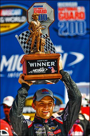 James Buescher celebrates his win in the NASCAR Camping World Truck Series Michigan National Guard 200.