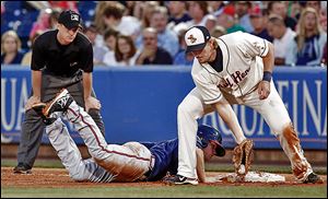 The Mud Hens’ Jordan Lennerton makes a  catch as  Gwinnett's Todd Cunningham dives back safely into first base during the sixth inning on Saturday.