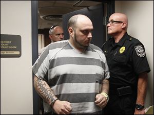 Joshua Michael Greenhill, left, leaves the courtroom after he is arraigned on a high misdemeanor firearms charge in Monroe County 1st District Court. Dundee police Chief David Uhl, right, said Monday that more charges could be filed.