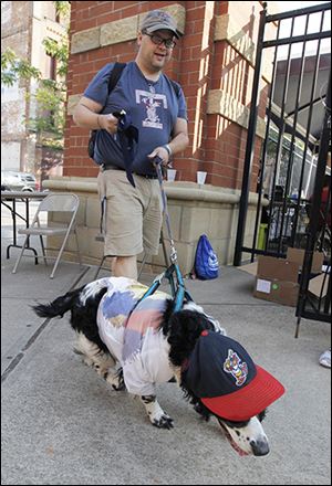 Matt Rose walks through the entrance to the stadium with his dog Duke, an English springer spaniel. Duke was named after a Pittsburgh Pirates' pitcher.