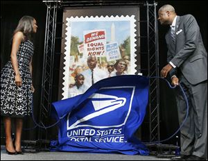 Actor  Gabrielle Union and Deputy Postmaster General Ronald Stroman unveil the U.S. Postal Service stamp commemorating the march’s 50th anniversary.