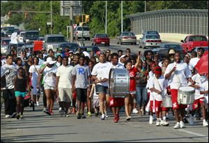 A crowd of more than 100 people march over the bridge on North Detroit Avenue during the 2 Miles 2 Stop Gang Violence march. Organizers say the march on Sunday could pay off in the future.