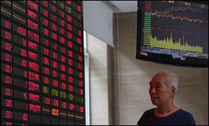 An investor looks at a stock prices monitor at a private securities company today in Shanghai, China. Asian stock markets mostly rose today after expectations for an imminent phasing out of the Federal Reserve's monetary stimulus program began to fade. 