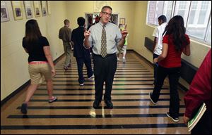 Principal Dave Yenrick directs students through the hallway after lunch on the first day of school at Waite High School. He’s been principal there for 19 years and has a long family history at the school. 