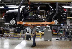 Jeff Caldwell, 29, right, a chassis assembly line supervisor, checks a vehicle on the assembly line at the Chrysler Jefferson North Assembly plant in Detroit