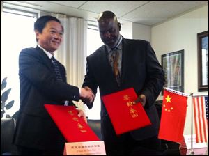 Toledo Mayor Mike Bell and Gao Guohui, deputy secretary-general of the Shenzhen Municipal government, shake hands after signing a cooperative agreement between the two cities.